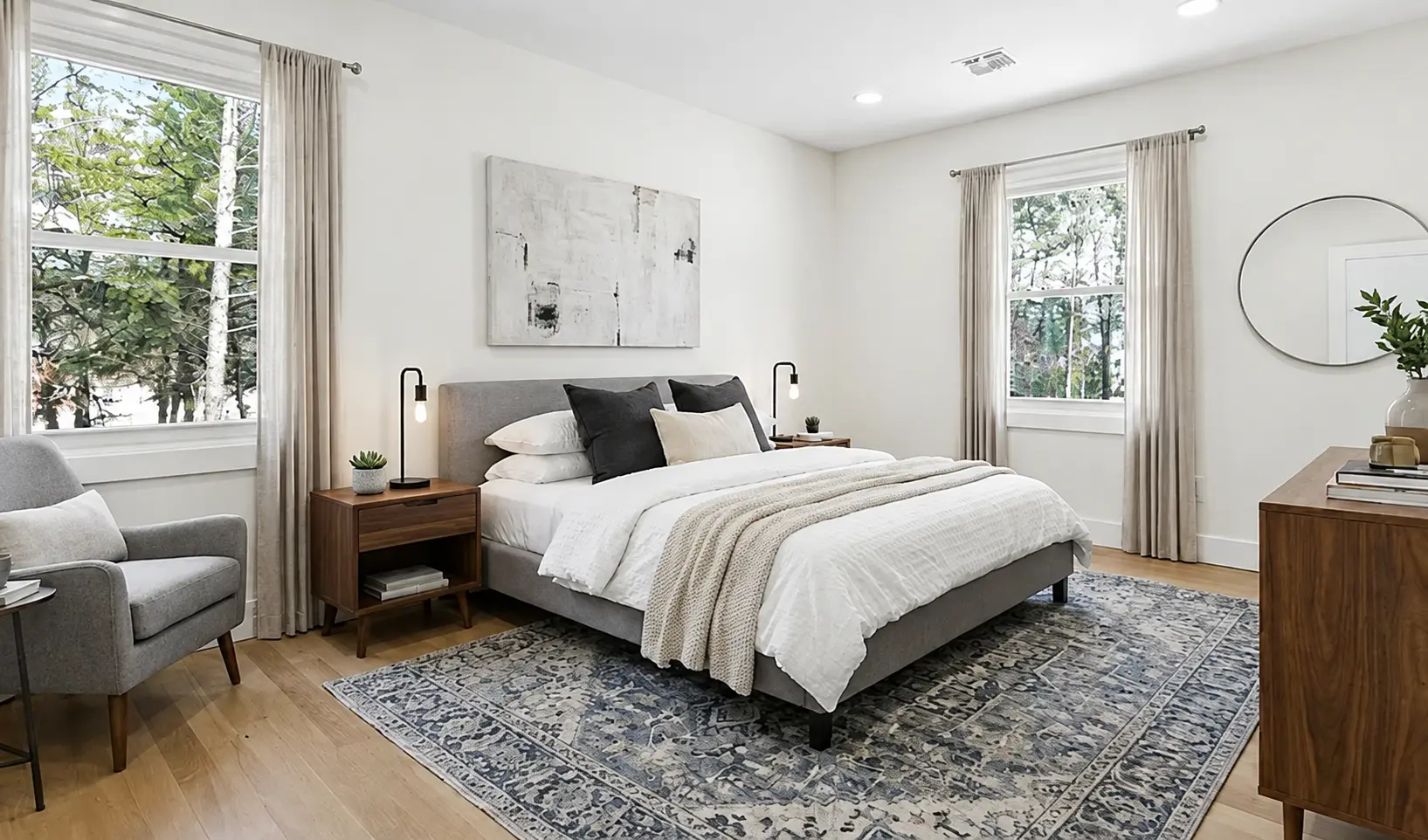 Bright primary bedroom addition with upholstered bed and daylight windows
