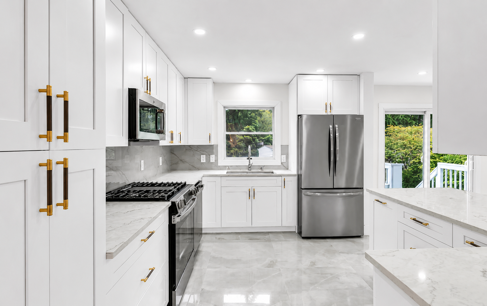 White shaker kitchen with brass handles, marble backsplash, and porcelain tile floor