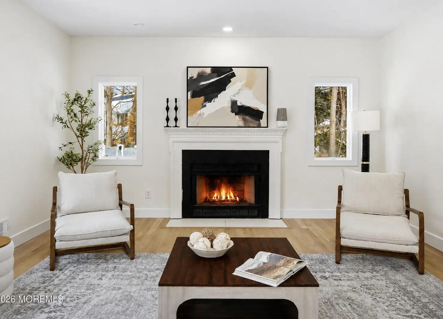 Renovated living room with a white fireplace surround and light oak floors